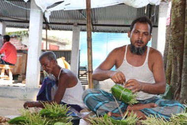 Asyalı satıcı, Bangladeş 'teki dükkanında betel yaprağı satıyor.