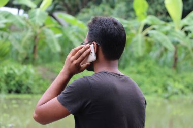 Genç bir iş adamının cep telefonuyla konuşmasının arkası. Yeni projeden bahsediyorum. Çalışma konsepti