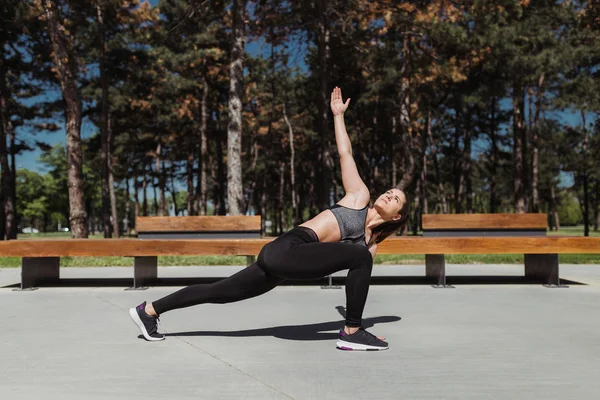 Açık havada çalıştırdıktan sonra güzel sportif Kafkas esmer kadın kadın streç. Maraton eğitim yaparken kadın uygun. Fitness motivasyon. Sağlıklı atlet kız parkta güneşli günde germe.