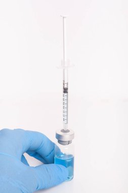 Doktor elinde ilaç şişesi ve şırınga tutuyor..