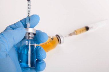 Doktor elinde ilaç şişesi ve şırınga tutuyor..