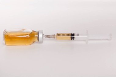 Beyaz arka planda şırınga ve ilaç şişesi.