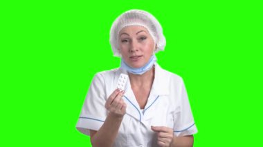Olgun kadın doktor hap sunan.