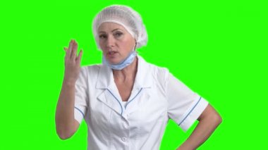 Kadın doktor yeşil ekranda tartışıyor.