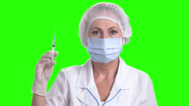 Mujer doctora sosteniendo jeringa en pantalla verde . — Vídeos de Stock