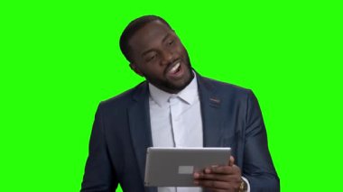 Yeşil ekranda dijital tablet kullanarak başarılı bir iş adamı.