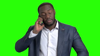 Cep telefonuyla konuşurken kendine güvenen genç işadamı.