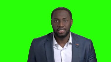 Afro Amerikalı adam yüz buruşturma yapım üzerinde yeşil perde.