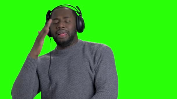 Mann mit Kopfhörer tanzt auf grünem Bildschirm. — Stockvideo