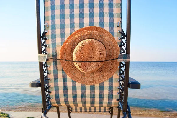 Close up rear view sun hat attached to deck chair.