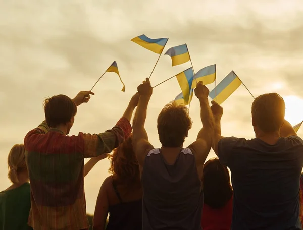 Visão traseira, silhueta de pessoas ucranianas com bandeiras . — Fotografia de Stock