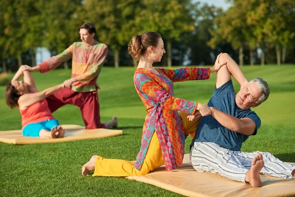 Gente haciendo ejercicios de yoga al aire libre . — Foto de Stock