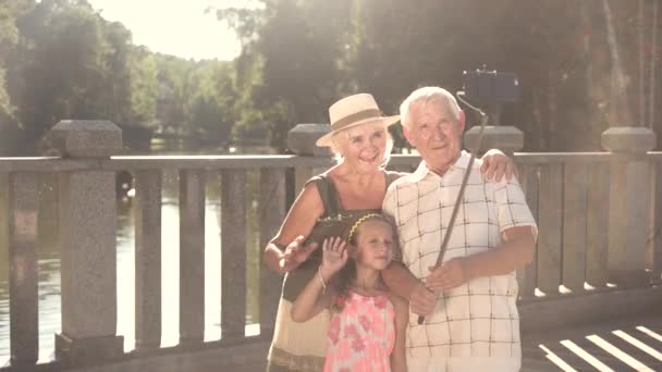 Großeltern mit Enkelin machen Selfie. — Stockvideo