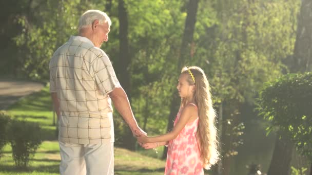 Farfar handledning hans barnbarn i park. — Stockvideo