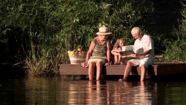 Grandparents and child near river. — Stock Video