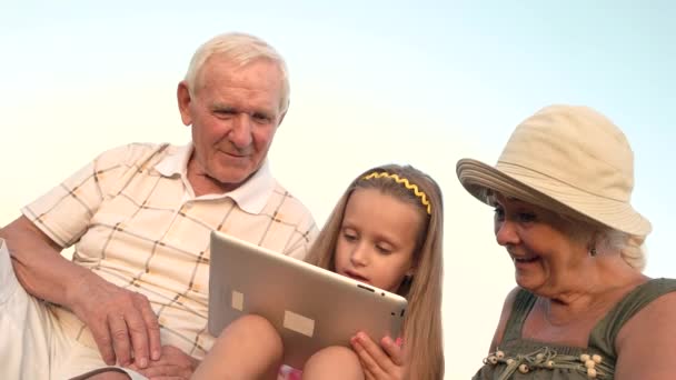 Enkelin mit PC-Tablet und überraschter Großmutter. — Stockvideo