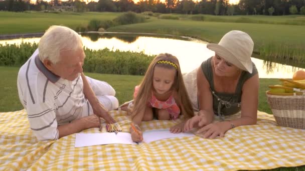 Abuelos ayudando a su nieta a dibujar . — Vídeos de Stock