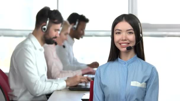 Glada asiatiska office flicka med medarbetare bakgrund. — Stockvideo