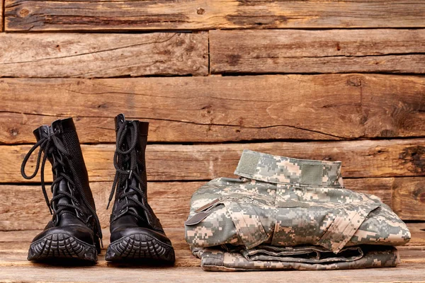 Ropa militar plegada y botas de combate . — Foto de Stock