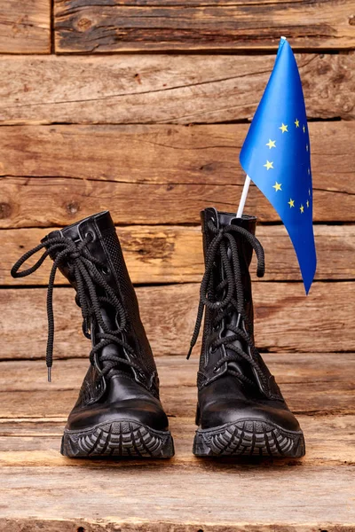Par de botas negras con bandera de la unión europea en madera . — Foto de Stock