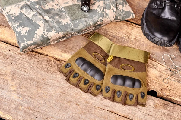 Parmaksız eldiven ve Kamuflaj giysileri ahşap üzerine çift.