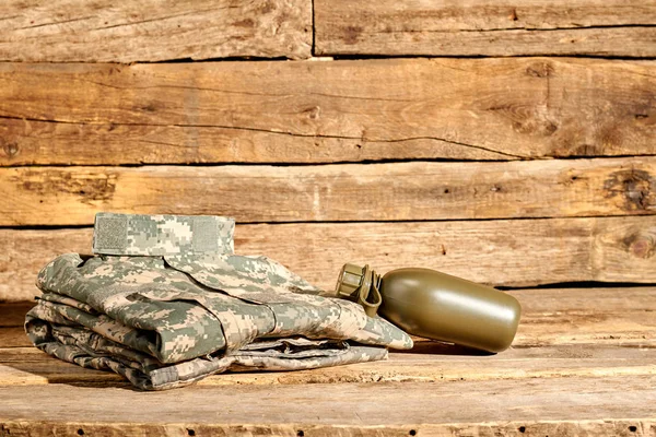 Folded soldier uniform and bottle.