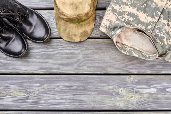Botas de combate negras, gorra militar y ropa . — Foto de Stock