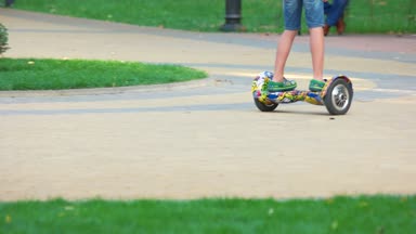 Gyro scooter Kömür topakları yolda sürme çocuk.