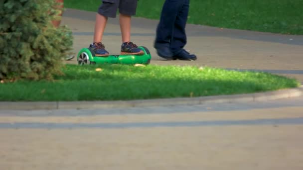 Fahrt auf grünem Gyroscooter in einem Park. — Stockvideo