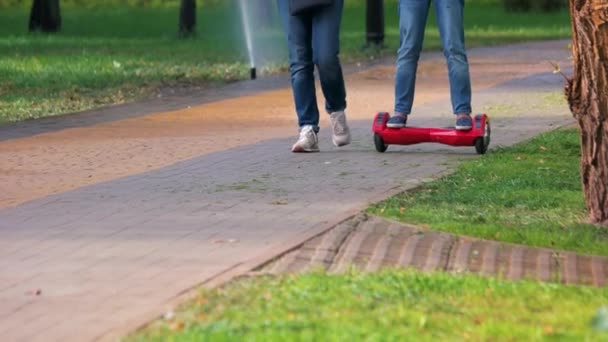 Mädchen fährt roten Gyroscooter im Park. — Stockvideo