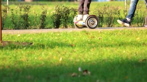 Kind rijden gyroscooters in het park. — Stockvideo