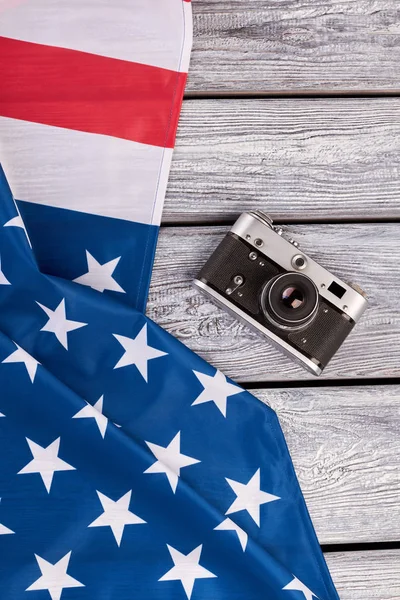 USA flag and vintage camera, top view.