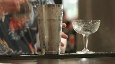 Kokteyl shaker dökülen barmen. Şampanya uçan daire doldurma, yakın çekim.