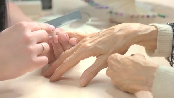Manikiurzystka zgłoszenia paznokcie do starszych kobiety. — Wideo stockowe