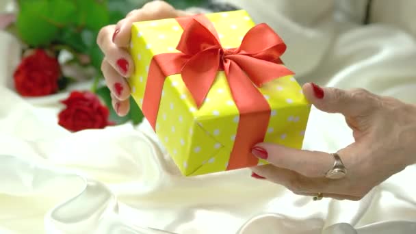 Elegante gift box in handen van de oudere vrouw. — Stockvideo