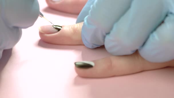 Manicura pintando un patrón en la uña del cliente . — Vídeo de stock