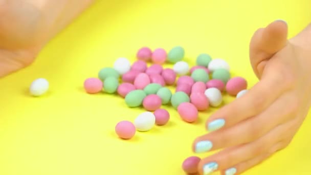 Маникюрные руки и разноцветные сладкие конфеты . — стоковое видео