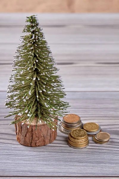 Piccolo albero di Natale artificiale e colonne di monete . — Foto Stock