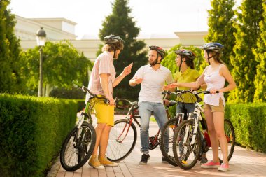 Grup Genç neşeli bisikletçiler açık havada.