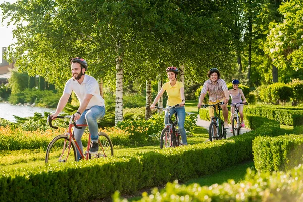 Чотири веселі друзі катаються на велосипеді надворі . — стокове фото