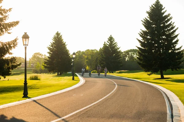 People riding bikes down the road.