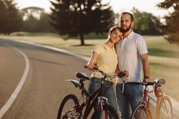 Lyckliga par med cyklar utomhus. — Stockfoto
