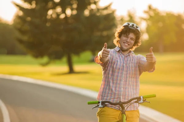 Beau gars sur vélo geste pouces vers le haut . — Photo