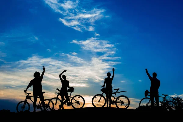 Silhouettes de jeunes cyclistes au coucher du soleil . — Photo