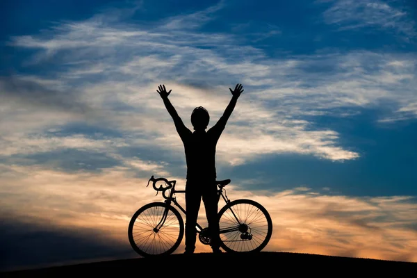 Молодий велосипедист підняв руки на небі заходу сонця . — стокове фото