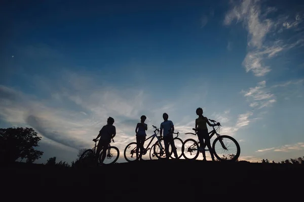 Cyclistes sur la colline au coucher du soleil . — Photo