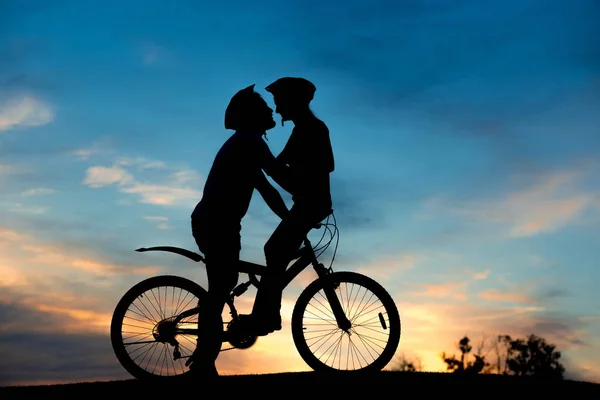 Pareja romántica de ciclistas se besa al atardecer . — Foto de Stock