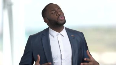 Kendine güvenen Afro-Amerikan işadamı kitleye konuşuyor.
