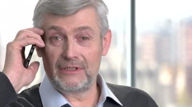 Yakışıklı olgun adam Evet. Cep telefonuyla konuşurken ve kameraya bakarak dost erkek kişi yakın çekim.