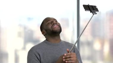 Genç siyah adam selfie stick kullanarak.